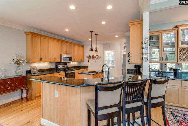 570 Wateree Key Ct, Winnsboro, SC 29180 - kitchen with stainless steel appliances, crown molding, light wood-style flooring, a peninsula, and a kitchen breakfast bar