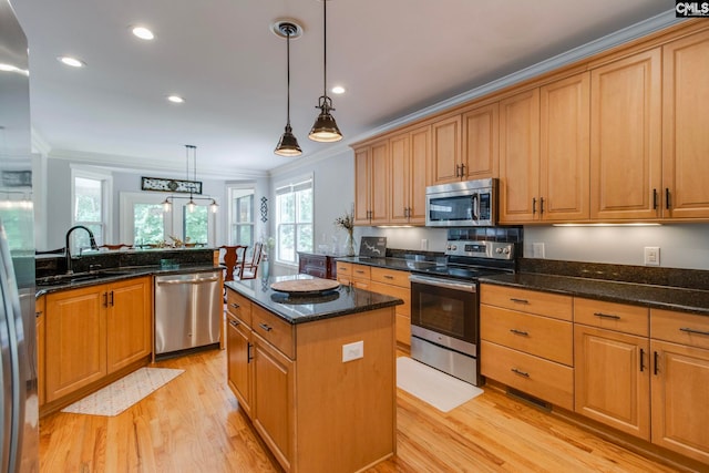 570 Wateree Key Ct, Winnsboro, SC 29180 - kitchen featuring appliances with stainless steel finishes, a sink, light wood-style flooring, crown molding, and a center island
