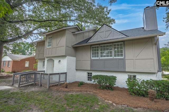 3102 Travis Ct, Columbia, SC 29204 - view of front facade with a deck, a chimney, brick siding, roof with shingles, and board and batten siding