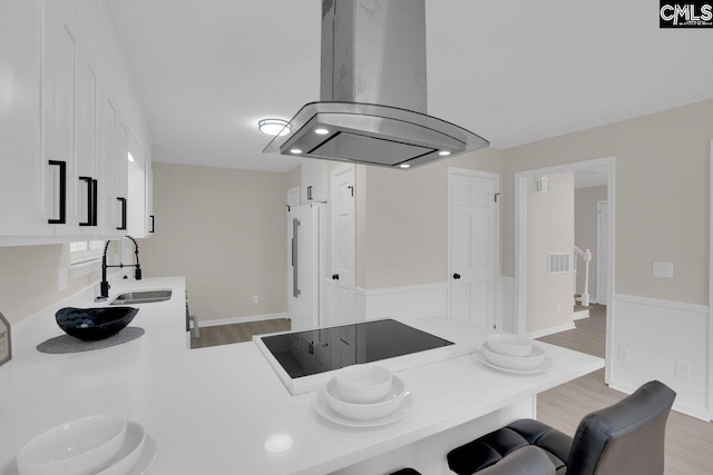 3102 Travis Ct, Columbia, SC 29204 - kitchen featuring a sink, island exhaust hood, a breakfast bar, light wood-type flooring, and light countertops
