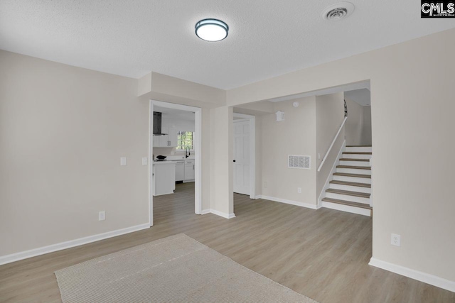 3102 Travis Ct, Columbia, SC 29204 - below grade area featuring light wood-style floors, a textured ceiling, baseboards, and stairway