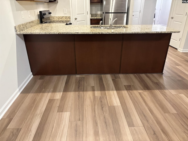 407 Eclipse Ln, Elgin, SC 29045 - kitchen with appliances with stainless steel finishes, a sink, a peninsula, wood finished floors, and light stone counters
