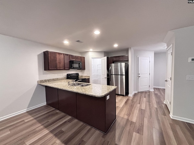 407 Eclipse Ln, Elgin, SC 29045 - kitchen with black appliances, a peninsula, dark wood-style floors, baseboards, and dark brown cabinetry
