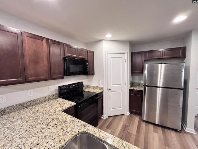407 Eclipse Ln, Elgin, SC 29045 - kitchen featuring black appliances, wood finished floors, dark brown cabinets, light stone counters, and recessed lighting