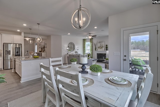 550 Edenwood Dr, Sumter, SC 29150 - dining room featuring a chandelier, healthy amount of natural light, a glass covered fireplace, wood finished floors, and recessed lighting