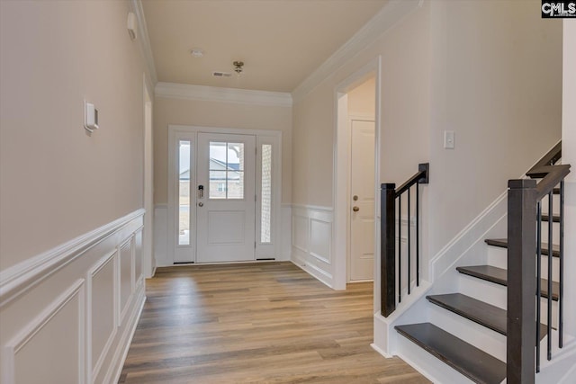 550 Edenwood Dr, Sumter, SC 29150 - entryway with crown molding, a decorative wall, a wainscoted wall, light wood-style flooring, and stairway