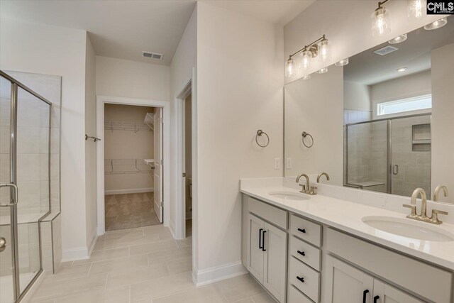 550 Edenwood Dr, Sumter, SC 29150 - bathroom featuring a shower stall, double vanity, a spacious closet, and baseboards
