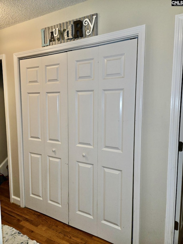 detailed view of wood finished floors and a textured ceiling