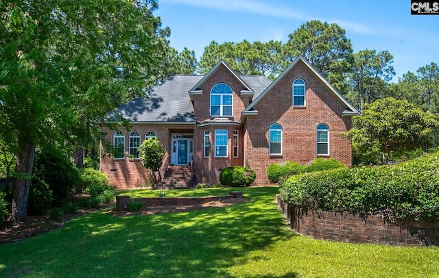 view of front of house featuring brick siding and a front yard