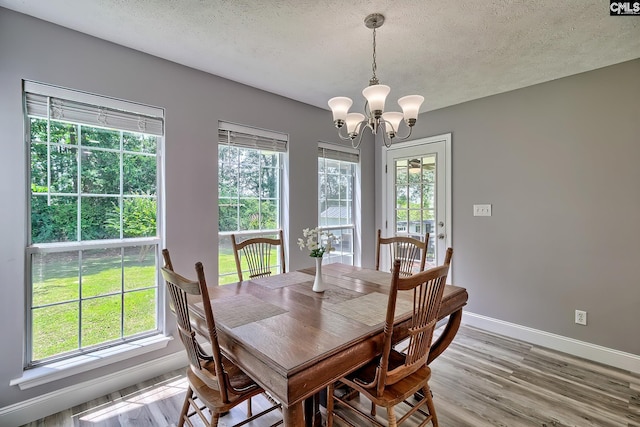 1240 Windmill Rd, Leesville, SC 29070 - dining room with a chandelier, a textured ceiling, baseboards, light wood-style floors, and healthy amount of natural light
