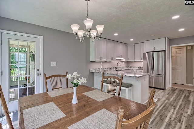 1240 Windmill Rd, Leesville, SC 29070 - dining space featuring light wood-type flooring, a textured ceiling, recessed lighting, and a chandelier