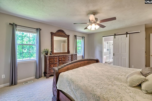 1240 Windmill Rd, Leesville, SC 29070 - bedroom with a barn door, a textured ceiling, baseboards, light carpet, and a ceiling fan