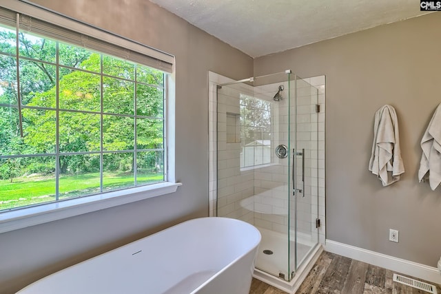 1240 Windmill Rd, Leesville, SC 29070 - full bath with wood finished floors, a shower stall, healthy amount of natural light, and a freestanding tub