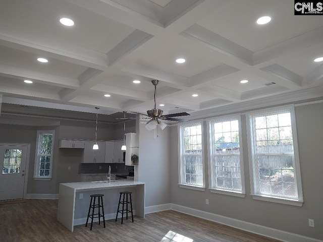 10 Saints Creek Pl, Irmo, SC 29063 - kitchen with a sink, coffered ceiling, baseboards, a kitchen bar, and recessed lighting