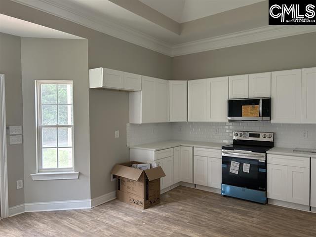 10 Saints Creek Pl, Irmo, SC 29063 - kitchen featuring stainless steel appliances, decorative backsplash, white cabinetry, light wood-type flooring, and ornamental molding