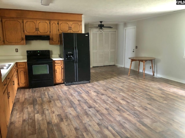 1171 Indian Creek Pt, Saluda, SC 29138 - kitchen with black appliances, under cabinet range hood, wood finished floors, and ceiling fan