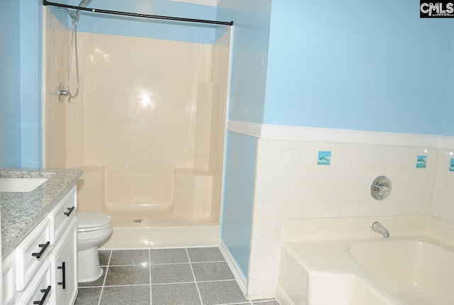 bathroom featuring tile patterned flooring, a garden tub, vanity, a walk in shower, and toilet