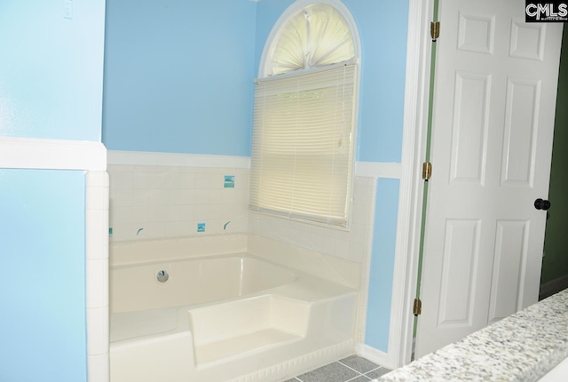 bathroom with a bath and tile patterned floors