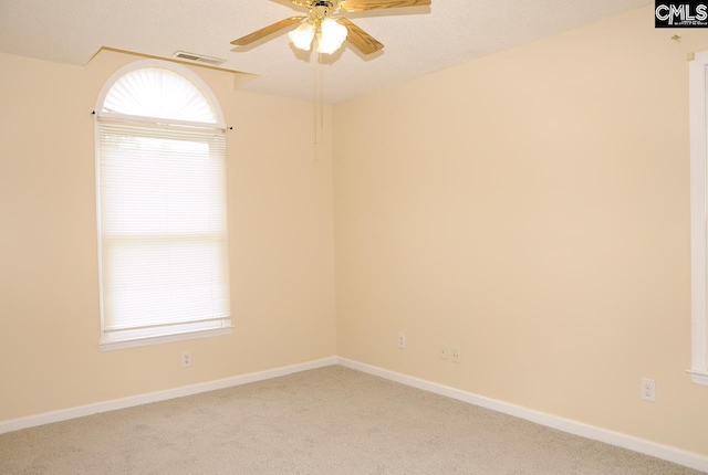 carpeted empty room with ceiling fan and baseboards