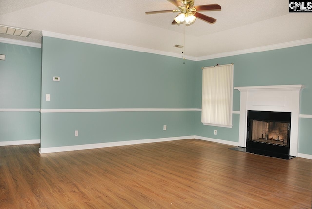 unfurnished living room with wood finished floors, ornamental molding, ceiling fan, a fireplace with raised hearth, and baseboards