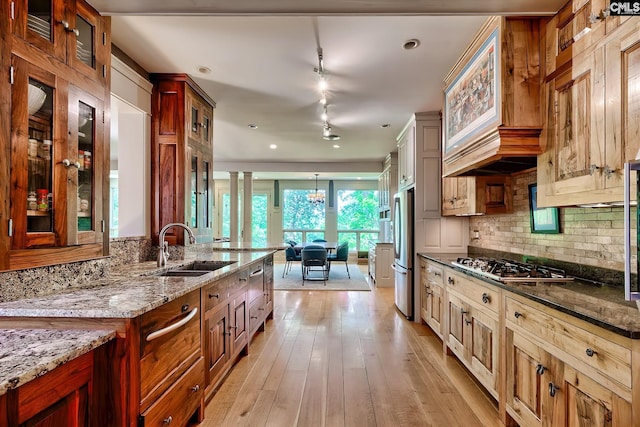 109 Broad Bluff Pt, Irmo, SC 29063 - kitchen with a sink, stainless steel appliances, decorative backsplash, light stone counters, and glass insert cabinets