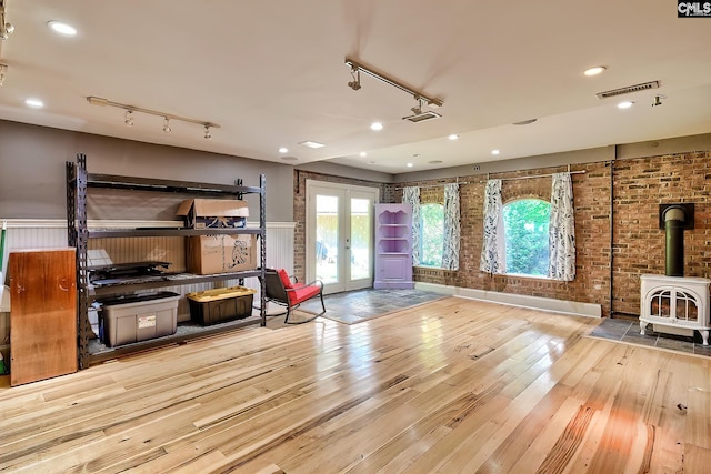 109 Broad Bluff Pt, Irmo, SC 29063 - living area with rail lighting, a wood stove, french doors, hardwood / wood-style flooring, and brick wall
