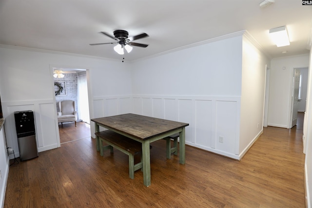 805 Mcrae Rd, Camden, SC 29020 - dining room with crown molding, a ceiling fan, wood finished floors, a wainscoted wall, and a decorative wall