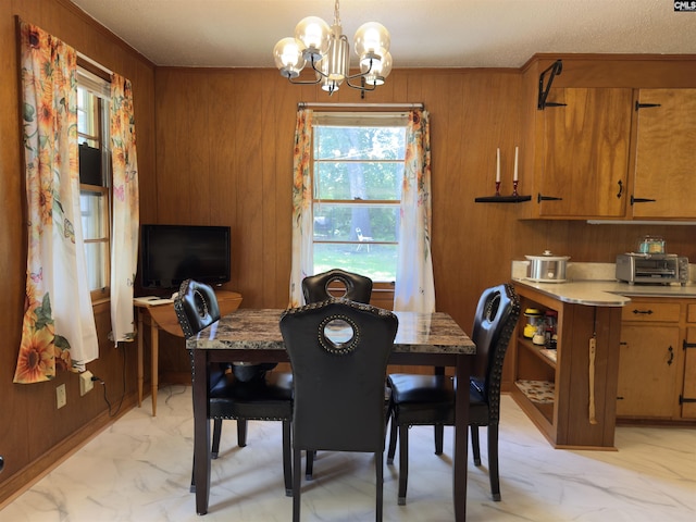 2313 Omega Dr, Columbia, SC 29223 - dining area featuring light marble finish flooring, a chandelier, crown molding, and wood walls