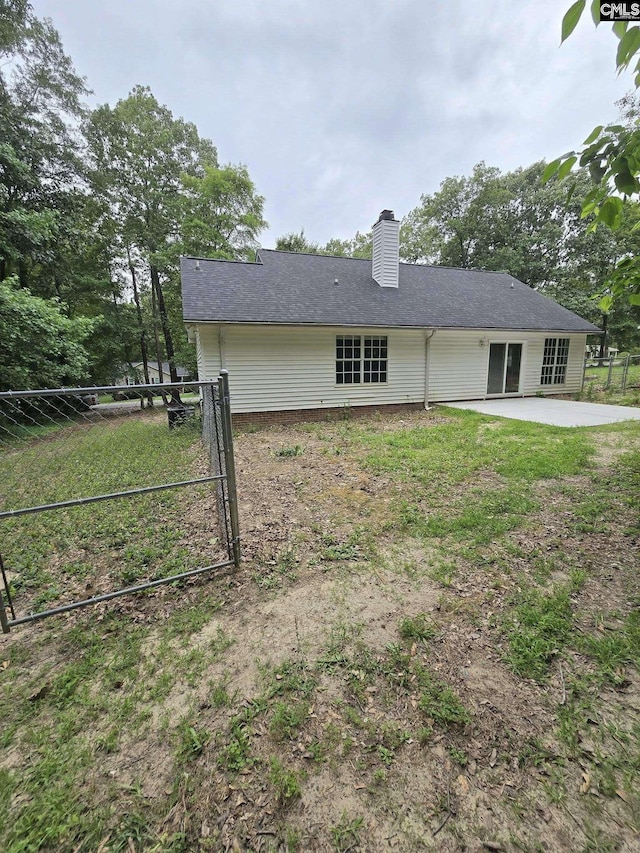 rear view of house featuring a patio and a chimney
