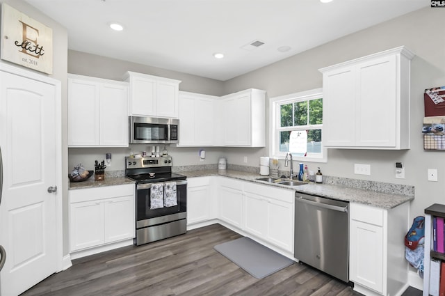 245 Long Iron Ct, West Columbia, SC 29172 - kitchen with appliances with stainless steel finishes, a sink, white cabinetry, dark wood-style flooring, and light stone countertops
