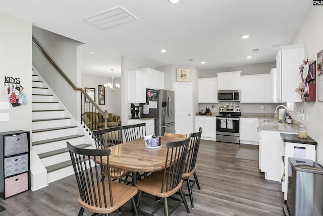 245 Long Iron Ct, West Columbia, SC 29172 - dining room featuring stairs, dark wood-style flooring, a chandelier, and recessed lighting