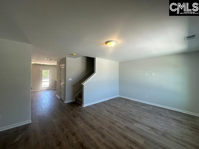 1023 Skyline Rd, Columbia, SC 29229 - unfurnished room with dark wood-type flooring, baseboards, and stairway