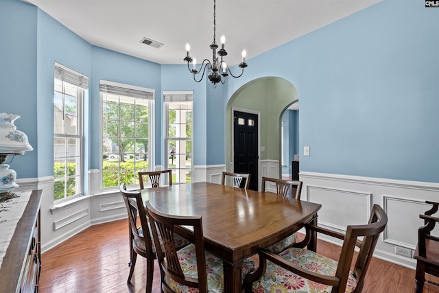 306 Austree Dr, Columbia, SC 29229 - dining area featuring arched walkways, a chandelier, wainscoting, plenty of natural light, and wood finished floors