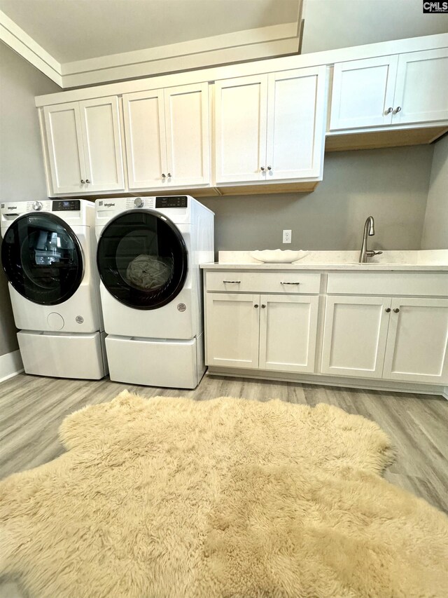 2215 High Bluff Loop, Lexington, SC 29072 - laundry room featuring cabinet space, washing machine and dryer, light wood-style flooring, and ornamental molding