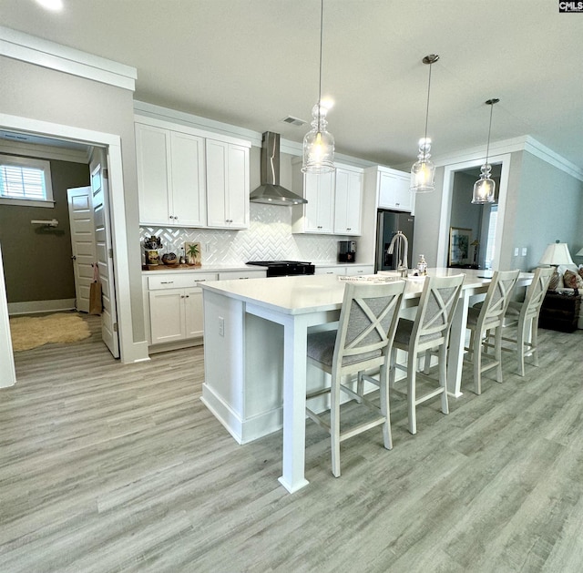 2215 High Bluff Loop, Lexington, SC 29072 - kitchen featuring wall chimney exhaust hood, ornamental molding, backsplash, light wood finished floors, and light countertops