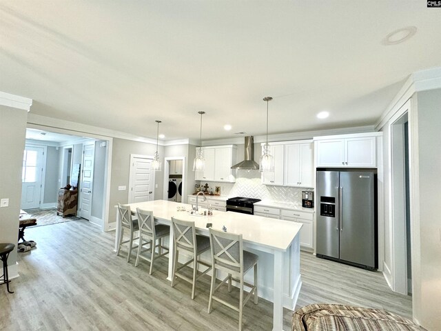 2215 High Bluff Loop, Lexington, SC 29072 - kitchen featuring high end refrigerator, wall chimney exhaust hood, a kitchen island with sink, white cabinetry, and ornamental molding