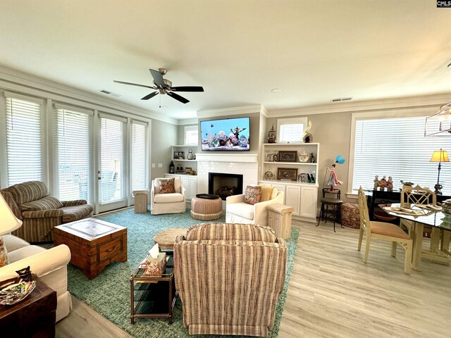 2215 High Bluff Loop, Lexington, SC 29072 - living room featuring crown molding, a fireplace, light wood-type flooring, and a ceiling fan