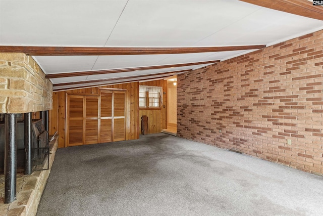 1514 Omarest Dr, Columbia, SC 29210 - unfurnished living room with a stone fireplace, carpet flooring, brick wall, and wood walls