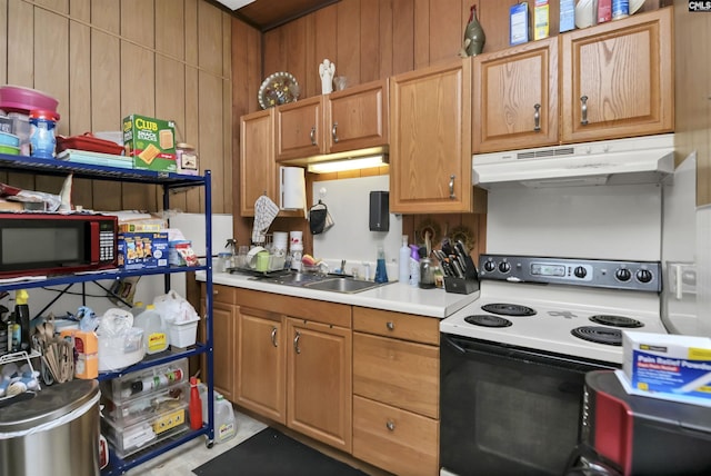 3334 Spring Dr, West Columbia, SC 29170 - kitchen featuring under cabinet range hood, electric stove, light countertops, a sink, and wooden walls