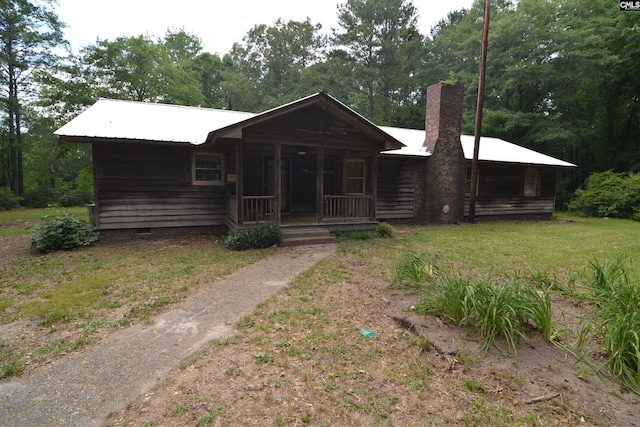 141 Frost Rd, Camden, SC 29020 - log cabin featuring covered porch, a chimney, metal roof, a front yard, and crawl space