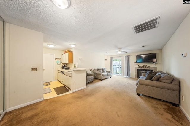 1211 Metze Rd Unit E6, Columbia, SC 29210 - living area featuring light colored carpet, a brick fireplace, ceiling fan, baseboards, and a textured ceiling