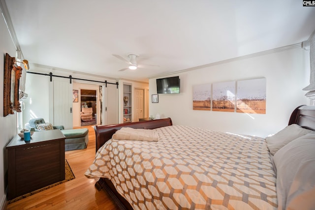3100 Grace Hill Rd, Columbia, SC 29204 - bedroom featuring ornamental molding, a barn door, wood finished floors, ceiling fan, and a closet