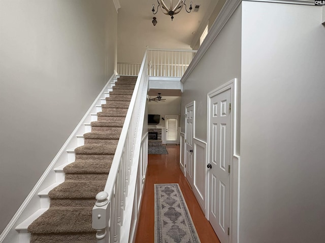 26 Peyton Rd, Columbia, SC 29209 - staircase with a high ceiling, a fireplace, a chandelier, wood finished floors, and a ceiling fan