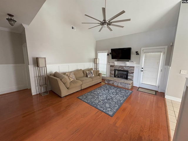 26 Peyton Rd, Columbia, SC 29209 - living area featuring ceiling fan, a stone fireplace, high vaulted ceiling, wood finished floors, and a wainscoted wall