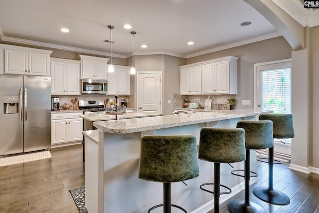 335 Hollow Cove Rd, Chapin, SC 29036 - kitchen featuring appliances with stainless steel finishes, arched walkways, a breakfast bar area, white cabinets, and wood finished floors
