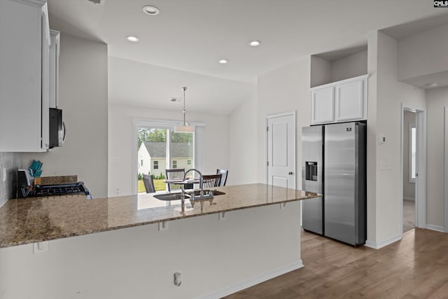 627 Cheehaw Ave, West Columbia, SC 29170 - kitchen with stainless steel fridge, a peninsula, light stone counters, range, and light wood-style flooring