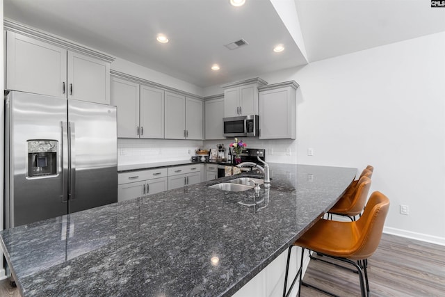 1401 Ardennes Dr, Elgin, SC 29045 - kitchen with appliances with stainless steel finishes, gray cabinetry, a sink, light wood-style floors, and dark stone countertops