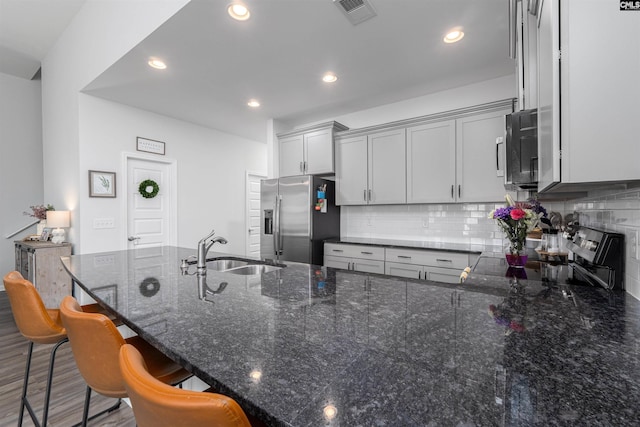1401 Ardennes Dr, Elgin, SC 29045 - kitchen featuring stainless steel appliances, a sink, decorative backsplash, dark stone counters, and recessed lighting