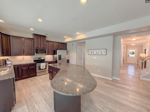 121 Ashford Way, Lexington, SC 29072 - kitchen with stainless steel appliances, light wood finished floors, a center island, decorative backsplash, and light stone countertops