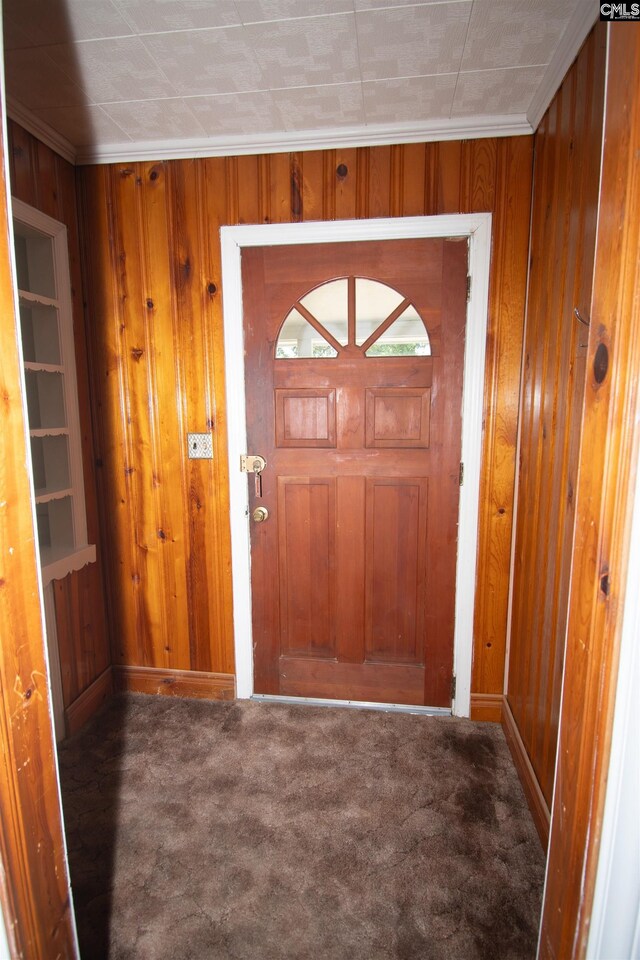 5199 Bethune Rd, Kershaw, SC 29067 - entryway featuring carpet flooring, baseboards, wood walls, and ornamental molding